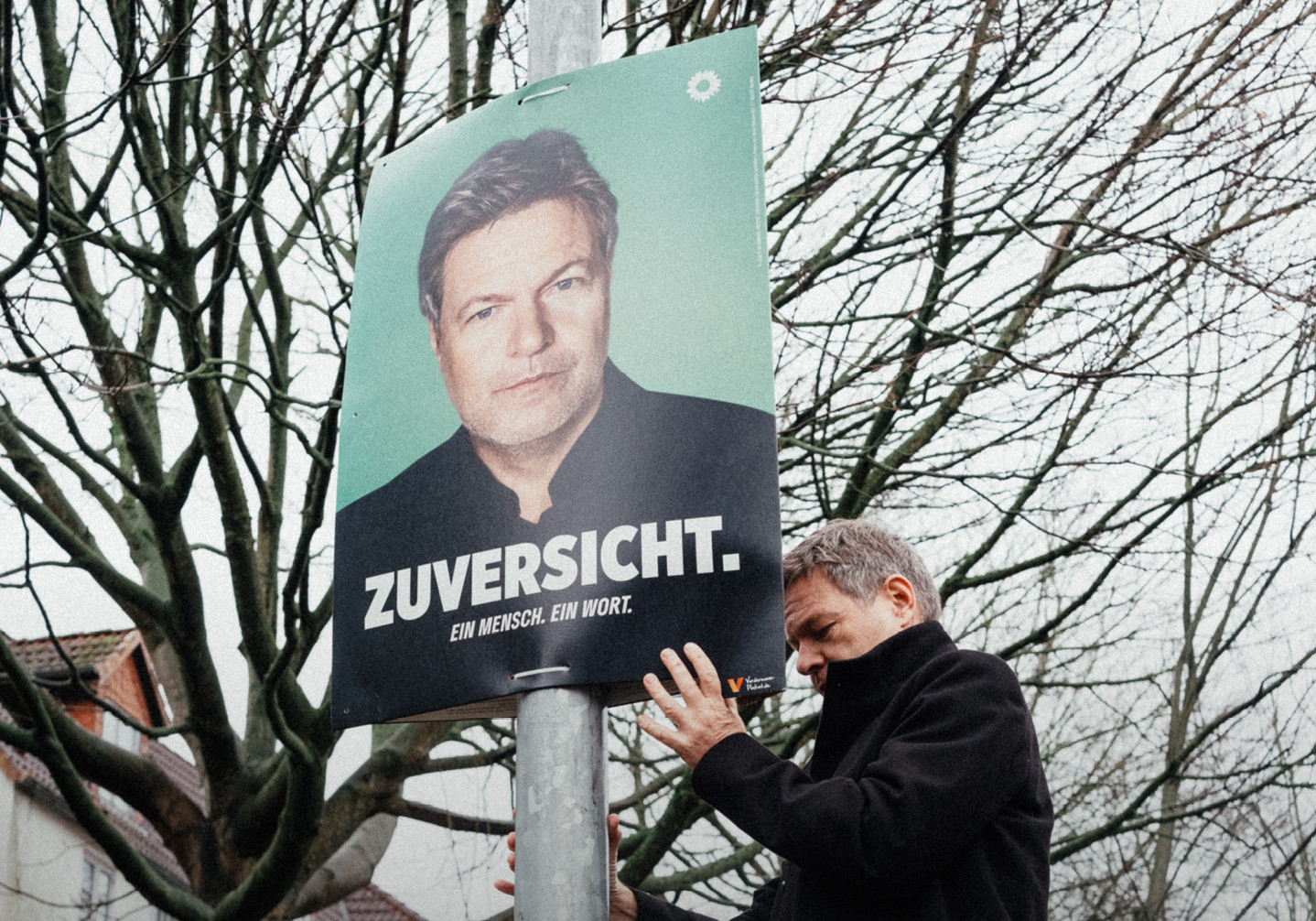 Robert Habeck bringt ein Plakat mit dem eigenen Konterfei mit den Worten: Zuversicht.Ein Mensch. Ein Wort.